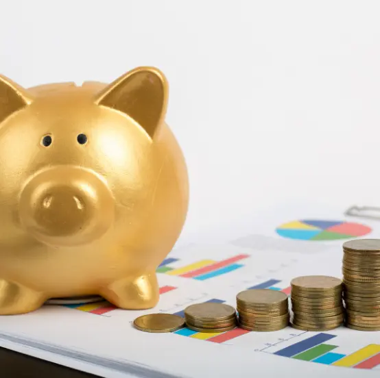 Halcón alcancía dorado junto a pilas de monedas sobre un informe financiero con gráficos para la gestión de financiamiento empresarial en Chile.